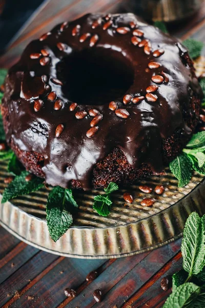 Sweet chocolate cake with cacao icing and decorated with mint