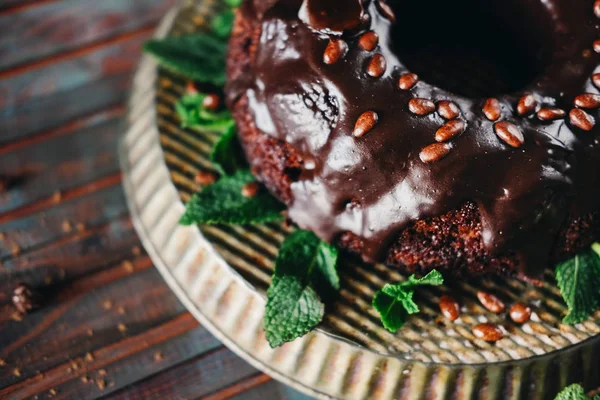 Sweet chocolate cake with cacao icing and decorated with mint