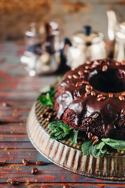 Sweet chocolate cake with cacao icing and decorated with mint