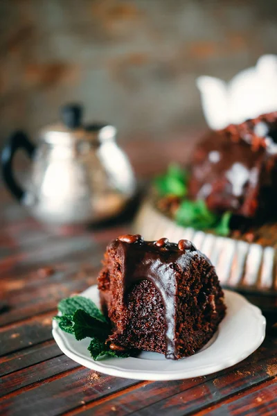 Sweet chocolate cake with cacao icing and decorated with mint