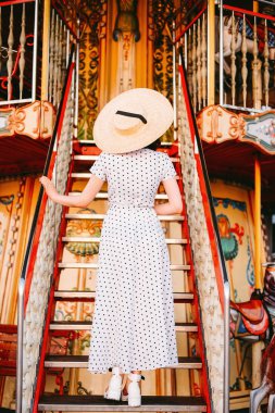 Lunaparktaki merdivenlerde duran zarif genç bayan. 