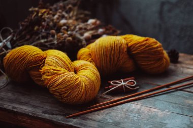 Bright yellow wool yarn skeins in rustic background