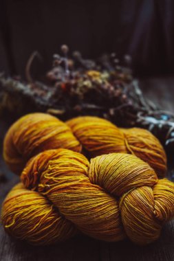 Bright yellow wool yarn skeins in rustic background