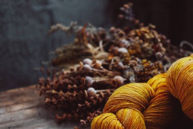 Bright yellow wool yarn skeins in rustic background