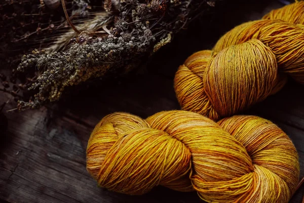 Bright yellow wool yarn skeins in rustic background — Stock Photo, Image
