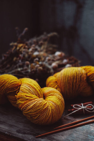 Ярко-желтая шерстяная пряжа на деревенском фоне

