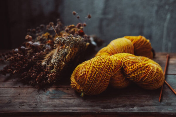 Ярко-желтая шерстяная пряжа на деревенском фоне
