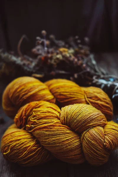 Lana amarilla brillante hilo madejas en fondo rústico — Foto de Stock