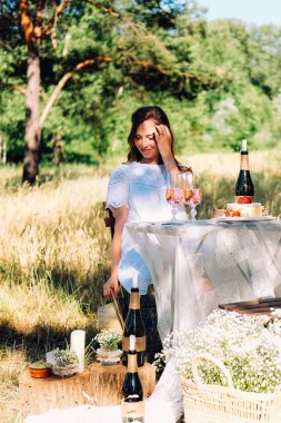 Yaz nişan pikniği. Masada oturan genç gelin akşam yemeği için servis yapıyor.. 