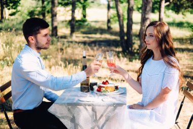 Yaz nişan pikniği. Masada oturan genç gelin akşam yemeği için servis yapıyor..