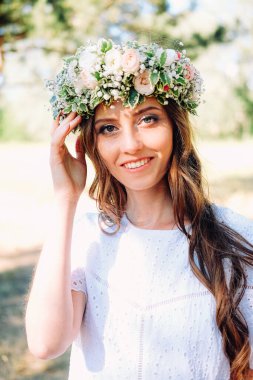 Beyaz çelenk giyen beyaz tenli genç bir kadın. Düğün davetlisi.