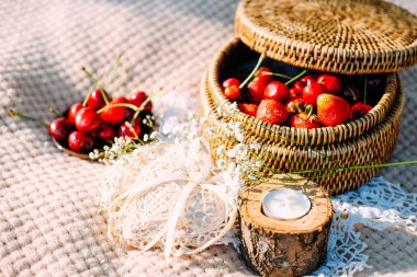 Çilek ve kirazlı, dantelli ve kır çiçekli piknik masası.