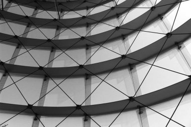 Kabloyla inşa edilmiş cam destekli bir binanın siyah beyaz fotoğrafı