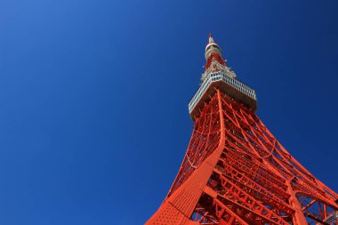 Aşağıdaki açık mavi gökyüzünden görünen çelik yapıyla inşa edilmiş renkli Tokyo Kulesi