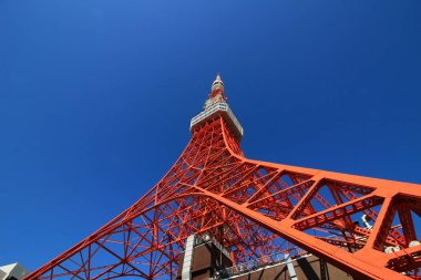 Aşağıdaki açık mavi gökyüzünden görünen çelik yapıyla inşa edilmiş renkli Tokyo Kulesi