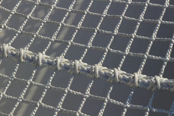 Abstract close up photo of a net woven with a white rope that makes you feel summer