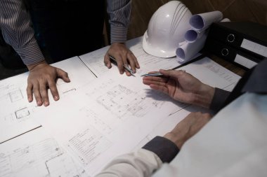 Mühendis ve ortak ofiste inşaat planı, vintage tonu, mühendislik konsepti hakkında tartışıyorlar..