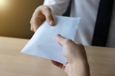 Beyaz bir zarfla rüşvet alan işadamı, ofiste başka bir adam, rüşvet ve yolsuzluk kavramı oluşturur..