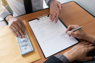 İş adamı bir sözleşme belgeleri imzaladı ve ofiste oturan başka bir işadamından rüşvet aldı, rüşvet ve yolsuzluk kavramı..