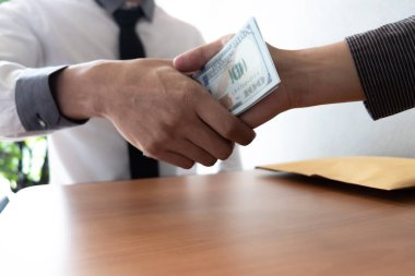 Ofis odasında el sıkışan ve rüşvet alan iki işadamı, rüşvet ve yolsuzluk kavramı.