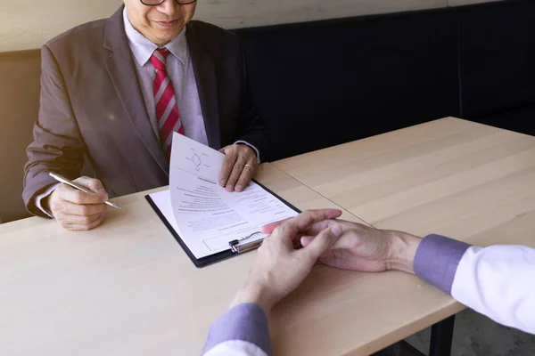 Interview employee reading a resume with the job seeker sitting in front, Job applications concepts.