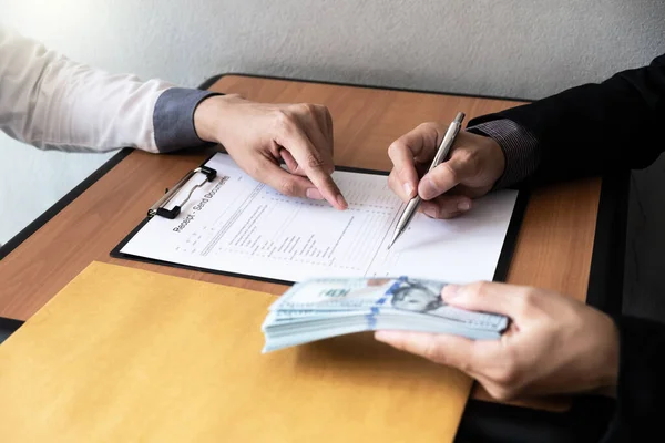 İş adamı bir sözleşme belgeleri imzaladı ve ofiste oturan başka bir işadamından rüşvet aldı, rüşvet ve yolsuzluk kavramı..