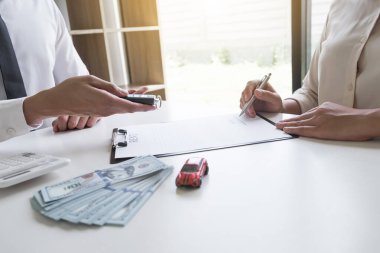 Müşteri araba kiralama anlaşmasını imzalıyor ve araba kiralama konseptini imzaladıktan sonra satıcıdan araba anahtarı alıyor..