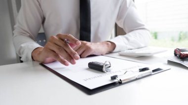 Araba satış temsilcisi ofisteki araba kiralama anlaşmasının kira ücretini hesaplıyor..