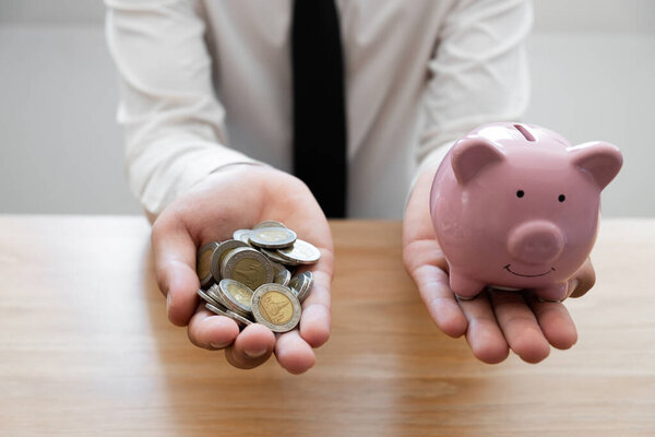 Businessman saving golden coin in hands, financial, save money concept.