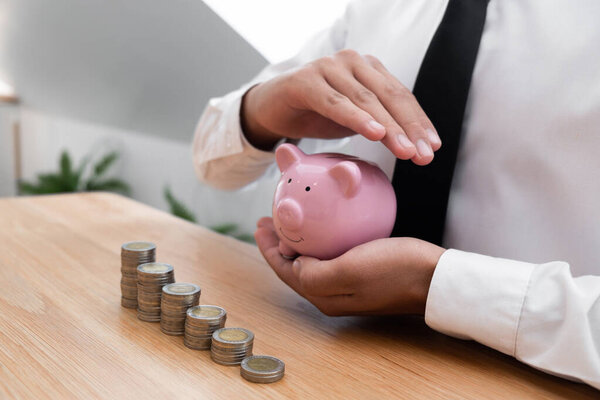 Businessman protecting piggy bank in hands. financial, save money concept.