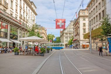 Tramvay ve İsviçre bayrağı ile sokak Bahnhofstrasse alışveriş Zürih