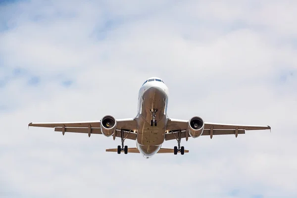 Airplane flying overhead - landing / takeoff - blue sky with clouds — Stock Photo, Image