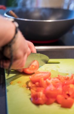 Şef kesim domates yeşil kesme tahtası üzerinde bıçak ile