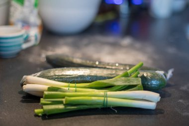 yeşil soğan ve taze salatalık arka plan bulanık masada yemek pişirmek için