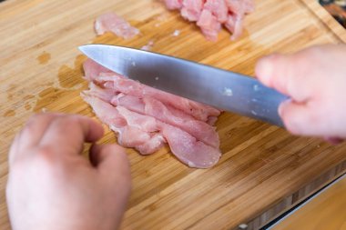 adam kesme tavuk eti ahşap kesme tahtası üzerinde