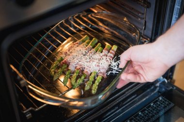 Yeşil kuşkonmaz pastırma ve parmesan peyniri ile fırın içine sarılmış.