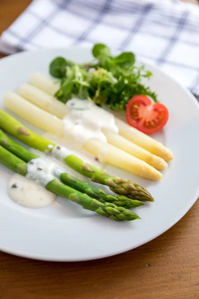 Green and white asparagus with tomato, green salad and sauce