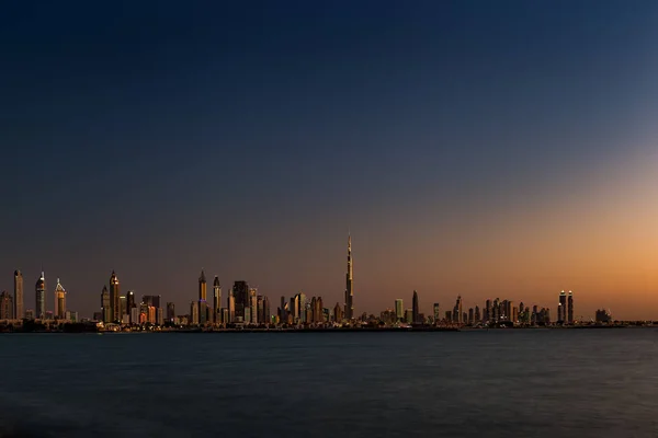 Una vista panorámica de Dubai, Emiratos Árabes Unidos al atardecer vista desde la playa de Jumeirah — Foto de Stock