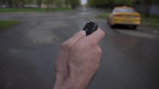 Un hombre abre un coche con control remoto — Vídeo de stock