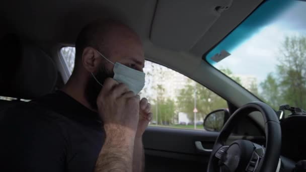 Een man met een baard met een masker die rijdt — Stockvideo
