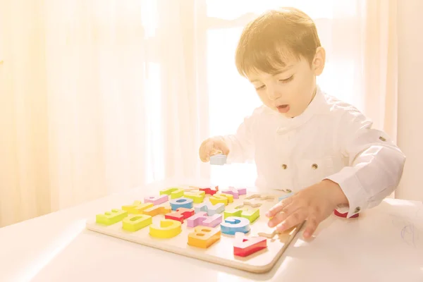 Kaukasische jongen speelt met kleurrijke houten letters — Stockfoto