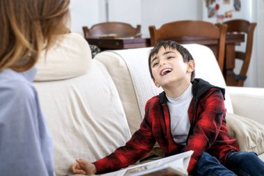 Annesi ona komik hikayeler anlatırken çocuk gülüyor.