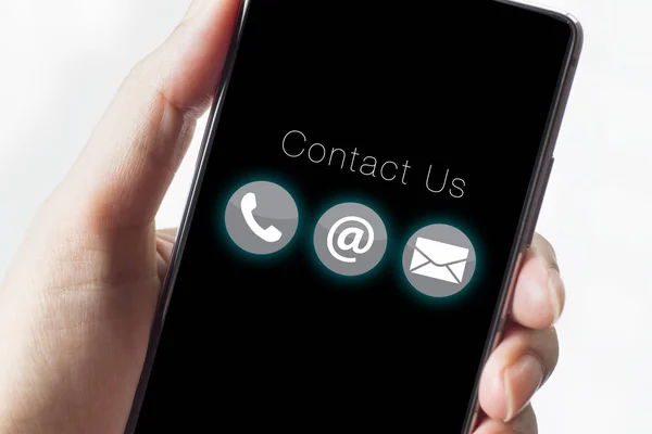 Contact us icons on smartphone with hand.
