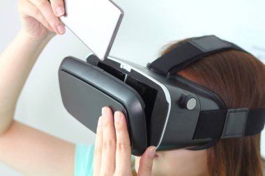 Evde sanal gerçeklik gözlüklü genç kadın.