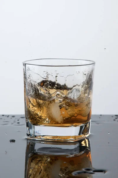 a glass of whiskey, drops, spray, splash of fluid, a stop time, after a hard-working day, rest time, Scottish traditions, Irish drink, Bourbon or Scotch,