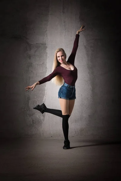 Blonde dancer in a dance pose. Sport, dance, body shape, fitness, training, beautiful pose, body lines, posing