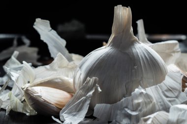 Sarımsak ve kabukla dolu bir hayat. Masada sarımsak, sağlıklı yiyecekler, aroma çeşnileri, köy tarzı, kafa ve dilimler.,