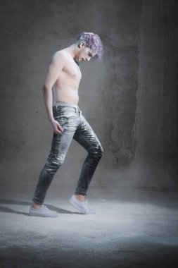 Gri arkaplan üzerinde un olan mor saçlı bir adam. Yaratıcı, alışılmadık, moda, cazibe, mor saç, poz, moda, sanat