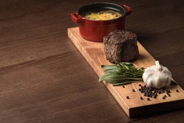 Ahşap bir tahtada tabak servisi. İlginç, alışılmadık, sarımsaklı ve biberiyeli et, sağlıklı yemek, doğal ürünler, yemek, güzel yemek.