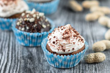 Gri ahşap arka planda çikolata ve fındıklı lezzetli çikolatalı kekler.